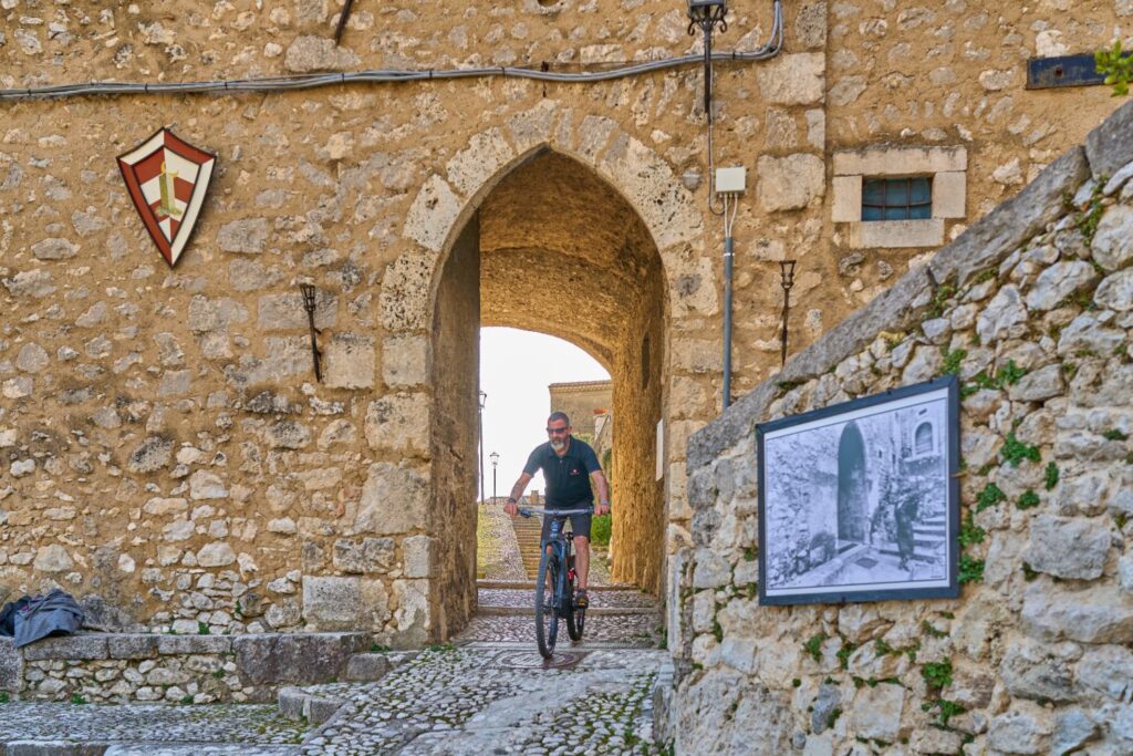 Escursione in e-bike attraverso un arco medievale nel borgo di San Donato Val di Comino